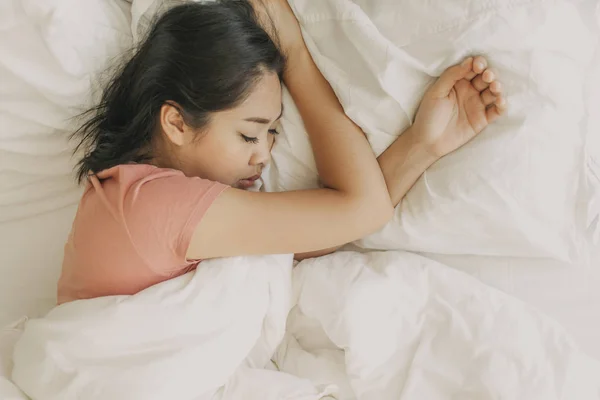Втомилася жінка відпочиває і спить у своїй теплій спальні . — стокове фото