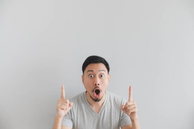 Wow ve boş alanda el noktası ile gri t-shirt adam sürpriz yüzü.