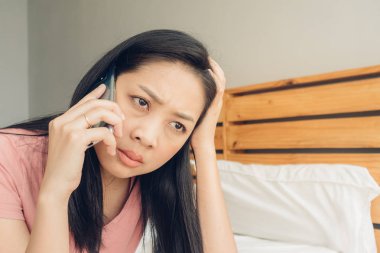 Üzgün kadın yatağında bir telefon görüşmesi var.