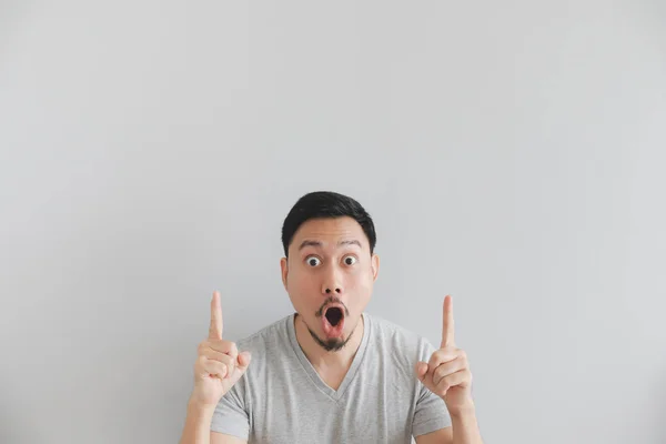 Wow y la cara sorprendida del hombre en camiseta gris con la mano en el espacio vacío . — Foto de Stock