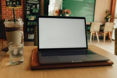 Beyaz boş ekranlı kahve kafede dizüstü bilgisayar.