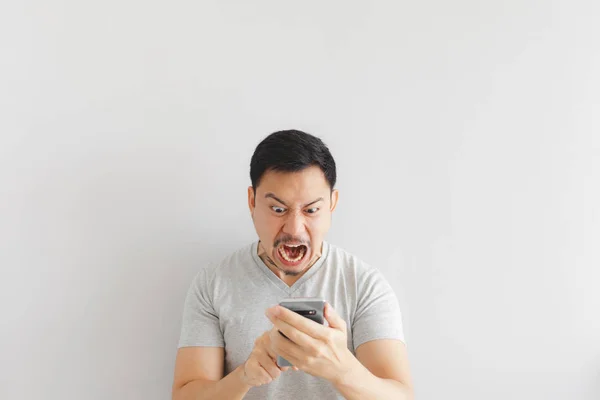 Homem irritado em camiseta cinza ficar bravo no smartphone . — Fotografia de Stock
