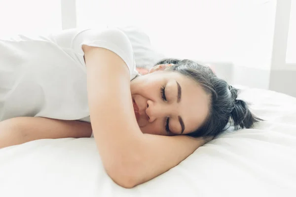 Asian woman is sleeping on her white cozy bed. — Stock Photo, Image