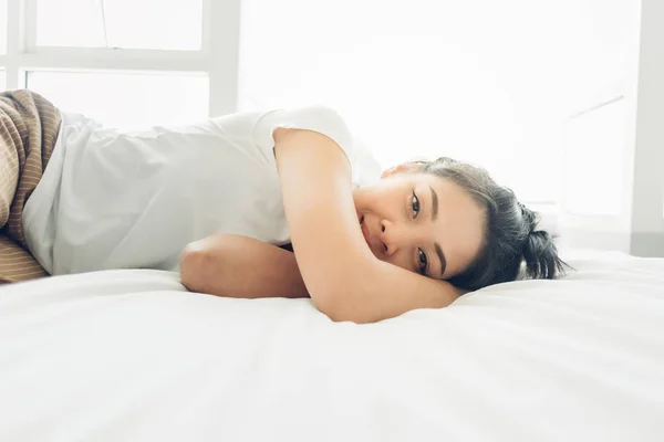 Aziatische vrouw is slapen op haar wit gezellig bed. — Stockfoto