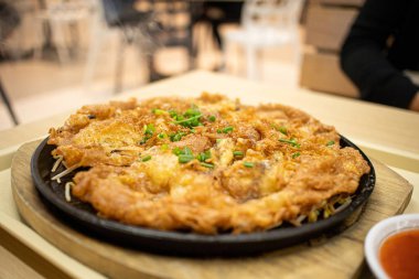 Tayland usulü istiridye omleti sıcak tavada servis ediliyor..