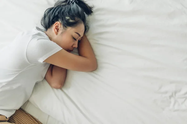 하얀 복제품 공간 이 있는 침대에서 자고 있는 여자의 맨 위 사진. — 스톡 사진