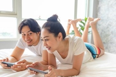 Mutlu çift yataklarında mobil oyun oynuyor..