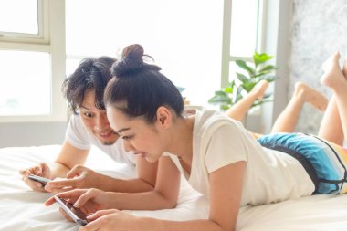 Mutlu çift yataklarında mobil oyun oynuyor..