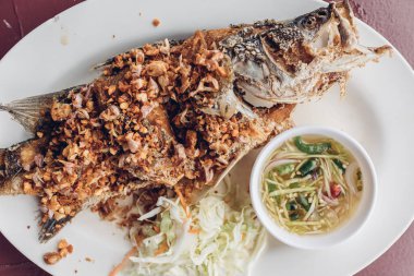 Tayland usulü kızarmış balık, sarımsak ve baharatlı sos..