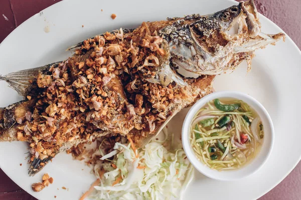 タイの揚げ魚にニンニクとスパイシーなソース. — ストック写真