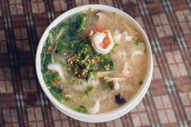 Beyaz kasede servis edilen baharatlı Tom yer elması deniz ürünleri..