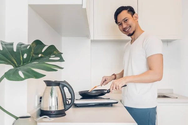 Man is cooking breakfast in the kitchen. — Stock Photo, Image