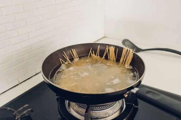 Boiling spaghetti with the pan in white kitchen. — Stock Photo, Image