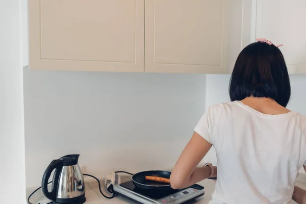 Wanita memasak sarapan sederhana di dapur putih yang nyaman. — Stok Foto