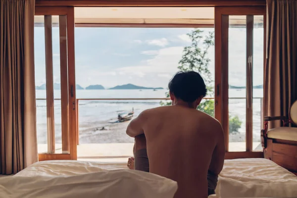 Man wake up in the room with sea view in the morning. Concept of vacation.