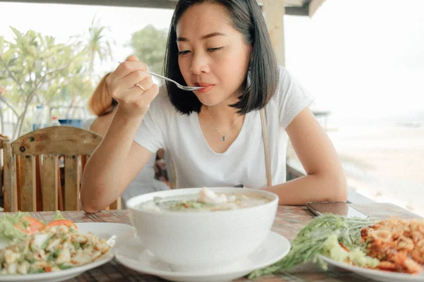 Mulher de t-shirt branca está comendo Tom Yam Seafood . — Fotografia de Stock