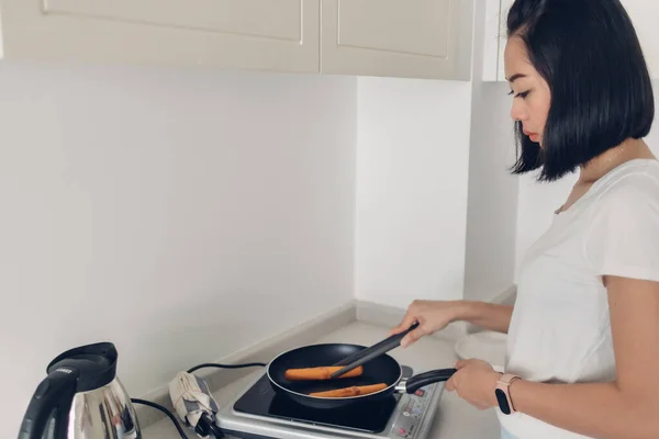 Woman is cooking simple breakfast in white cozy kitchen. — Stock Photo, Image