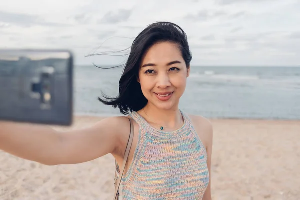 Gelukkig vrouw selfie zichzelf op het strand. — Stockfoto