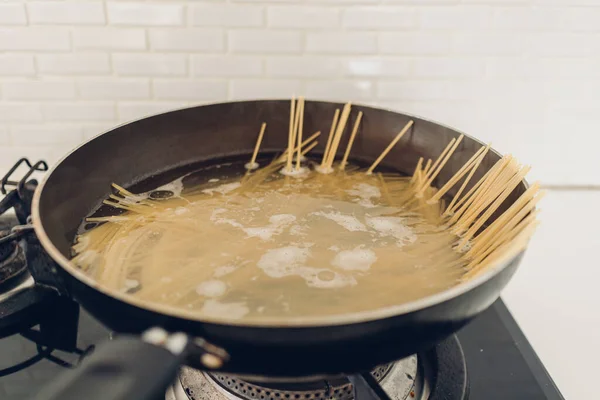 Boiling spaghetti with the pan in white kitchen. — Stock Photo, Image