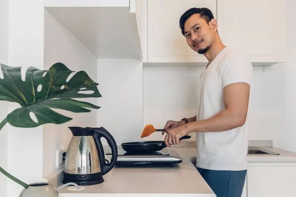 Man is cooking breakfast in the kitchen. — Stock Photo, Image