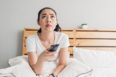 Kadın uzaktan kumandayı tutuyor ve ciddi ciddi drama dizisi izliyor..