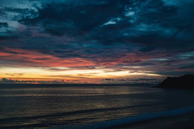 Denizin renkli bulutlu alacakaranlık gökyüzü.