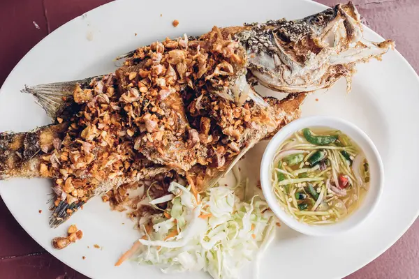 タイの揚げ魚にニンニクとスパイシーなソース. — ストック写真