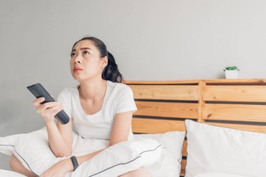 Kadın uzaktan kumandayı tutuyor ve ciddi ciddi drama dizisi izliyor..