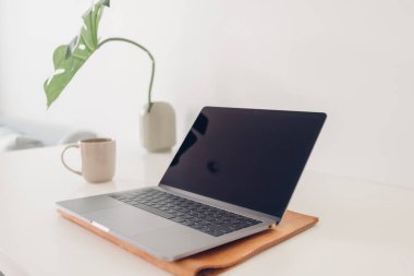 Fabrika dekorasyonu ve kahvesi olan minimal dizüstü bilgisayar çalışma alanı.