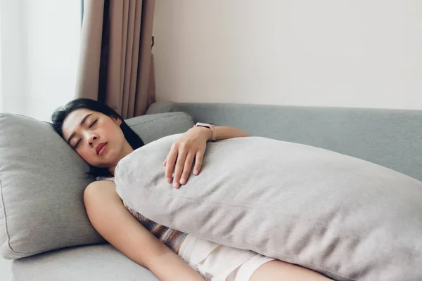 Mulher está dormindo no sofá sentindo relaxar em um dia cansado. — Fotografia de Stock