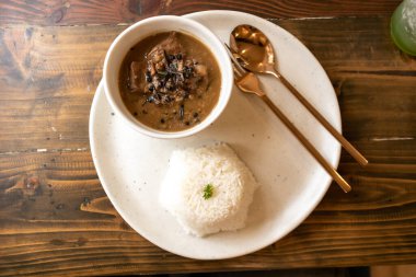 Biftek güveç seti klasik bir ahşap masada servis edilir..