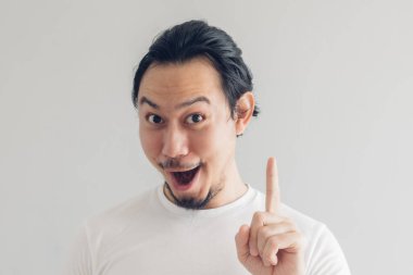 Funny grinning smile face of man in white t-shirt and grey background. clipart