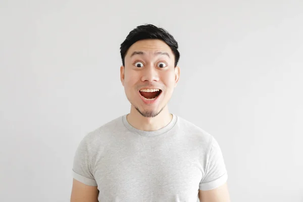 Shocked face of man in grey t-shirt and grey background. — Stock Photo, Image