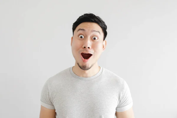 Shocked face of man in grey t-shirt and grey background. — Stock Photo, Image