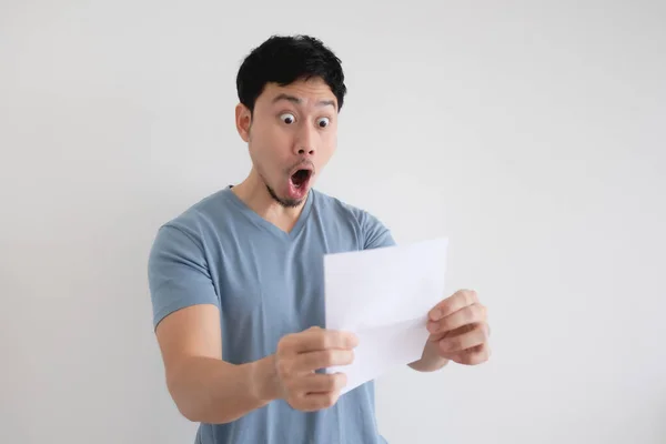 Man surprise and shocked by the letter in his hand on isolated background. — Stock Photo, Image