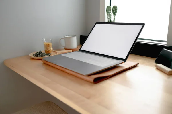 Laptop de exibição vazio branco em uma mesa de madeira. — Fotografia de Stock