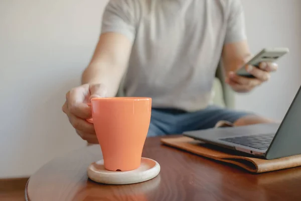 男人在笔记本电脑上工作的时候，正在拿起咖啡杯. — 图库照片