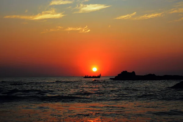 Barco con pescadores en el fondo de la puesta de sol en el mar . — Foto de Stock