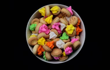 Endonezya renkli küçük ekmek atıştırmalıklar, bu aperatifler çok lezzetli ve tatlı tadı. boş bir siyah arka plan ile bir plaka üzerinde renkli küçük ekmek