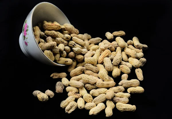 Boş siyah arka planda bir plaka üzerinde fıstık