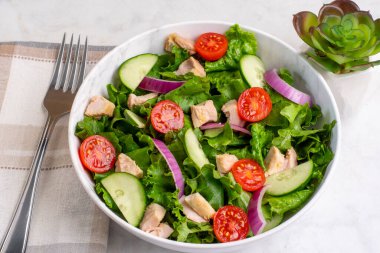  Domatesli salata, marul ve tavukla servis edilen salatalık.