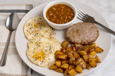 Biber ve maydanozlu yumurta sosisli börek, ev kızartması ve fırında fasulye ile servis edilir.