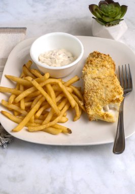 Kızarmış patates ve tarter soslu fırında mezgit.