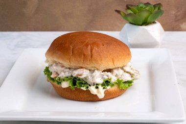 Çöreğin üzerinde marullu karides deniz ürünleri salatası.