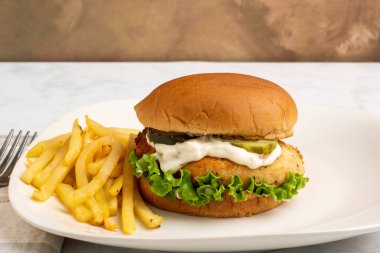 Salatalı somon burger, turşu ve tarter soslu patates kızartması.