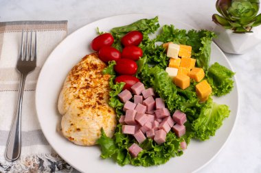 Marul, domates, jambon ve peynirli tavuk göğsü.