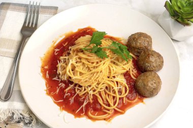 Maydanozlu spagetti köftelerle servis edilen sosun üzerinde dinleniyor.