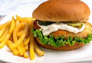 Salatalı somon burger, turşu ve tarter soslu patates kızartması.