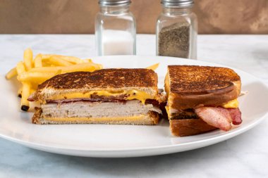 Erimiş peynirle patates kızartması arasında hindi ve pastırma.