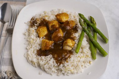 Sarımsaklı beyaz pirinç ve tavuk ısırığı soslu soğan.